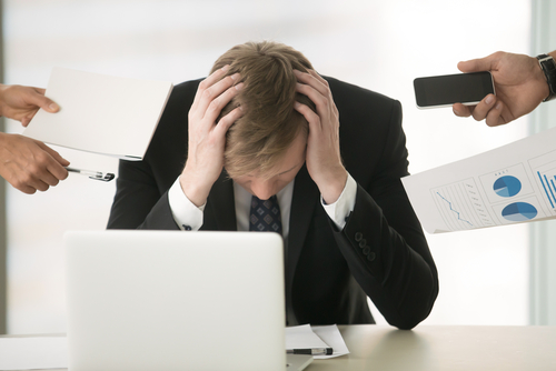 man with head down at desk